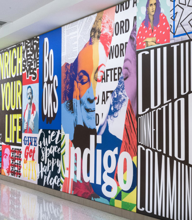 "A vibrant collage mural composed of bold typography, colorful stylized portraits, and abstract patterns, with prominent text including ""Enrich Your Life,"" ""Books,"" ""Indigo,"" and ""Culture."""