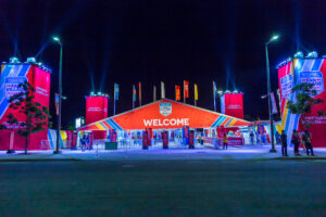 "Brightly lit World Cup Hockey 2016 Fan Village at night, with a large red ""WELCOME"" tent and surrounding banners."