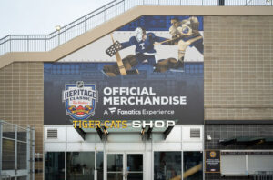 "Exterior view of an Official Merchandise and Tiger-Cats Shop, with a large mural of hockey players and the NHL Heritage Classic logo above the entrance."