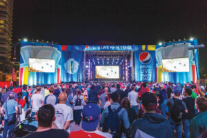 A large crowd watches a hockey game on big screens at the outdoor Pepsi LIVE Main Stage during the World Cup of Hockey 2016 at night.