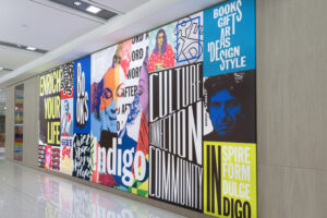 "A vibrant collage mural on a wall featuring bold text promoting books and culture, alongside stylized portraits."