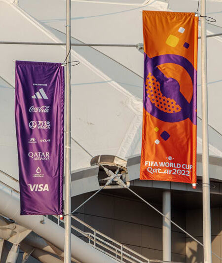 "Banners for the FIFA World Cup Qatar 2022, featuring the event logo and sponsor brands, hang at a stadium."