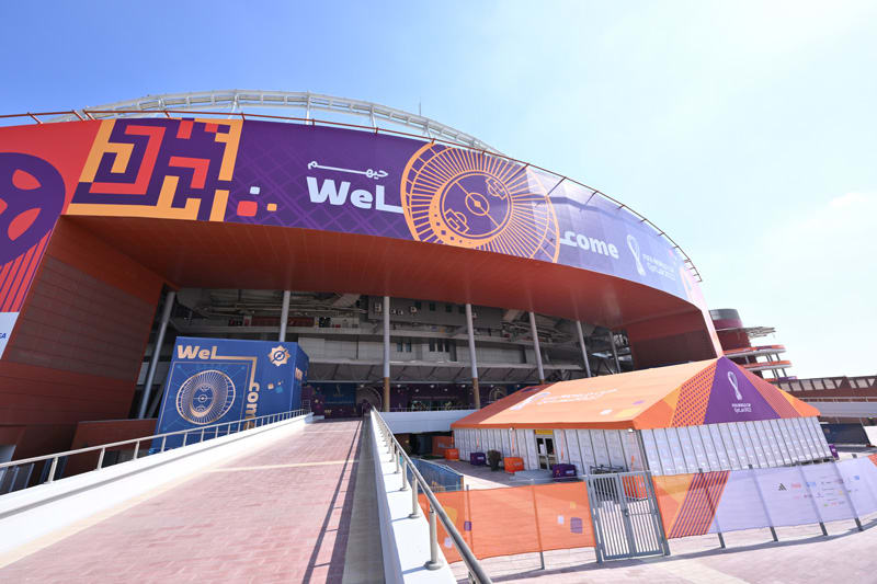 FIFA World Cup Qatar 2022 stadium entrance decorated with ""Welcome"" banners, an access ramp, and an orange tent.