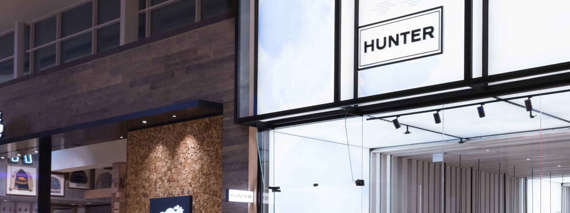 Modern store interior featuring a ""HUNTER"" sign, wood-paneled walls, and a glass entrance.