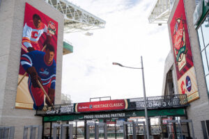 Stadium entrance Gate 3 adorned with large Tim Hortons Heritage Classic 2019 banners featuring Calgary Flames and Winnipeg Jets hockey players.