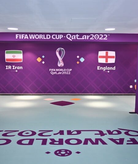 "A hallway decorated for the FIFA World Cup Qatar 2022, featuring flags of IR Iran and England on a purple wall."