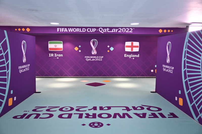 Purple hallway display for FIFA World Cup Qatar 2022, with flags of Iran and England.