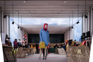 "Interior of a modern apparel store featuring mannequins in rain gear and various clothing on display, with digital screens showing a cloudy sky."