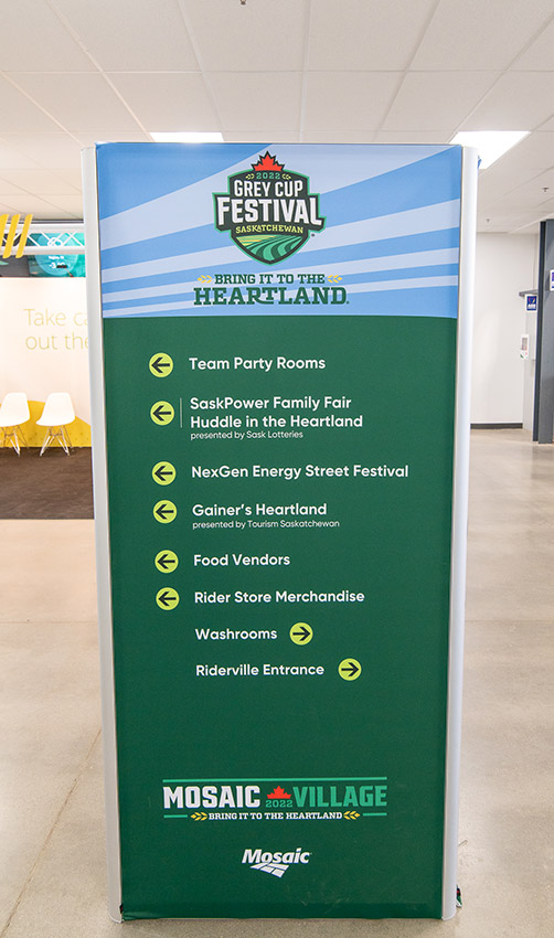 "A vertical directional sign for the 2022 Grey Cup Festival Saskatchewan, listing various event locations and services like party rooms, food vendors, and washrooms."