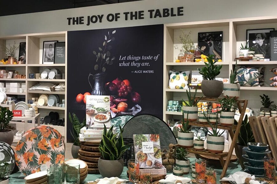 A store display of kitchenware, cookbooks, and home decor items under a sign reading ""THE JOY OF THE TABLE.""