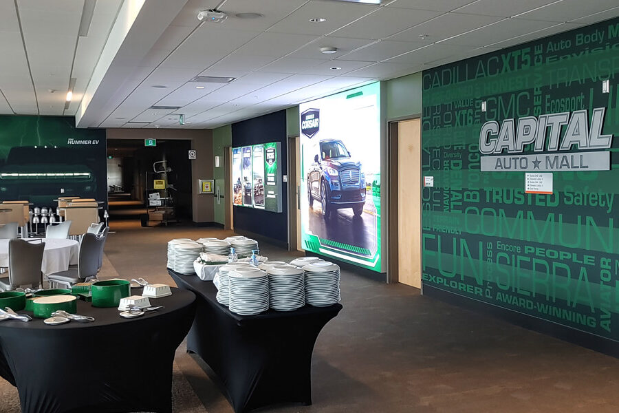 Capital Auto Mall event space with buffet tables, dining setups, and large vehicle display walls.