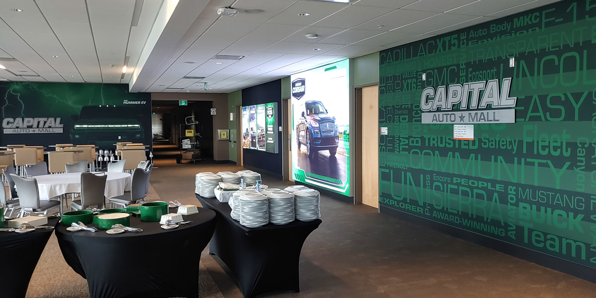 Capital Auto Mall event space with buffet tables, dining setups, and large vehicle display walls.