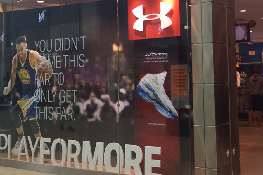 Under Armour store window display featuring Stephen Curry, Curry Two shoes, and the #PLAYFORMORE slogan.