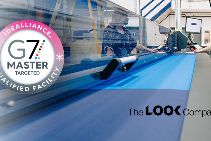 The LOOK Company's G7 Master Qualified printing facility is shown with two operators working at a large-format printer handling blue fabric.
