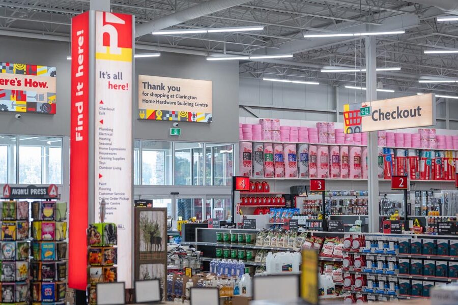 Interior of the Clarington Home Hardware Building Centre, showing prominent ""Here's How"" signage, diverse merchandise, and multiple checkout lanes.