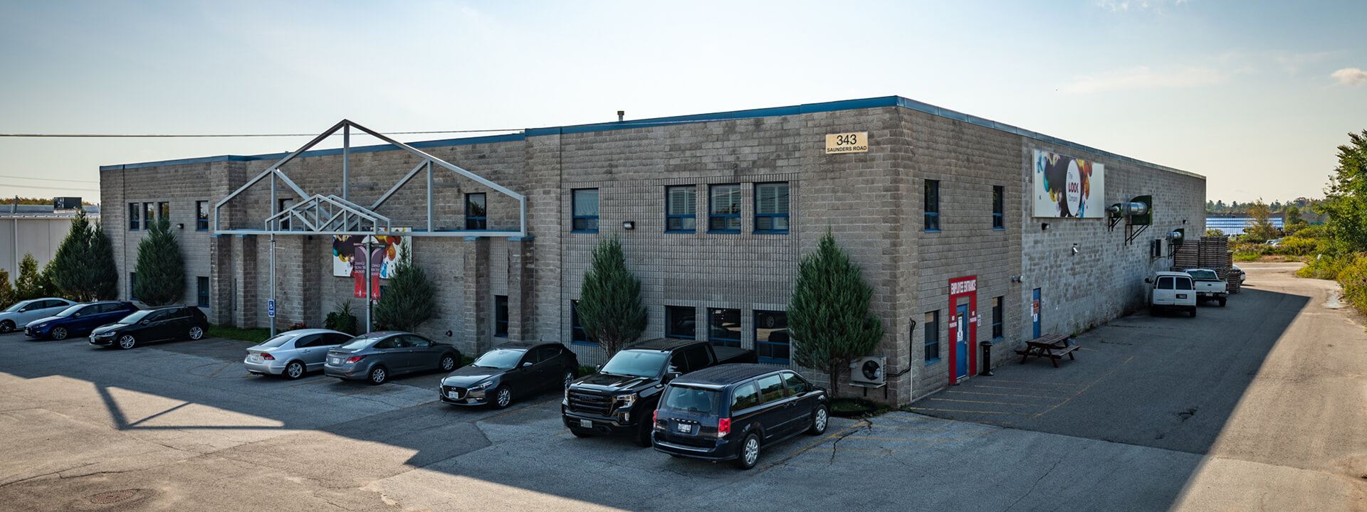 A grey brick commercial building for ""The Look Company"" at 343 Saunders Road, with a parking lot full of cars in front.