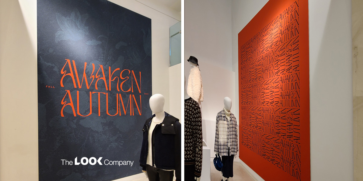 Two retail displays with mannequins and ""AWAKEN AUTUMN"" branding: a dark grey banner with orange text on the left, and an orange wall with black patterned text on the right.