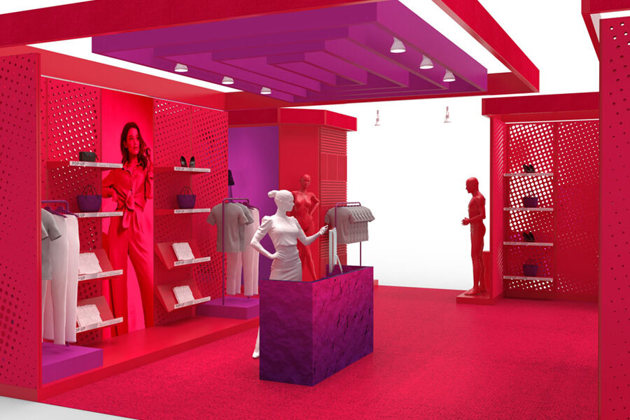 A vibrant red and magenta pop-up store interior displaying clothes, accessories, and mannequins with a perforated wall design.